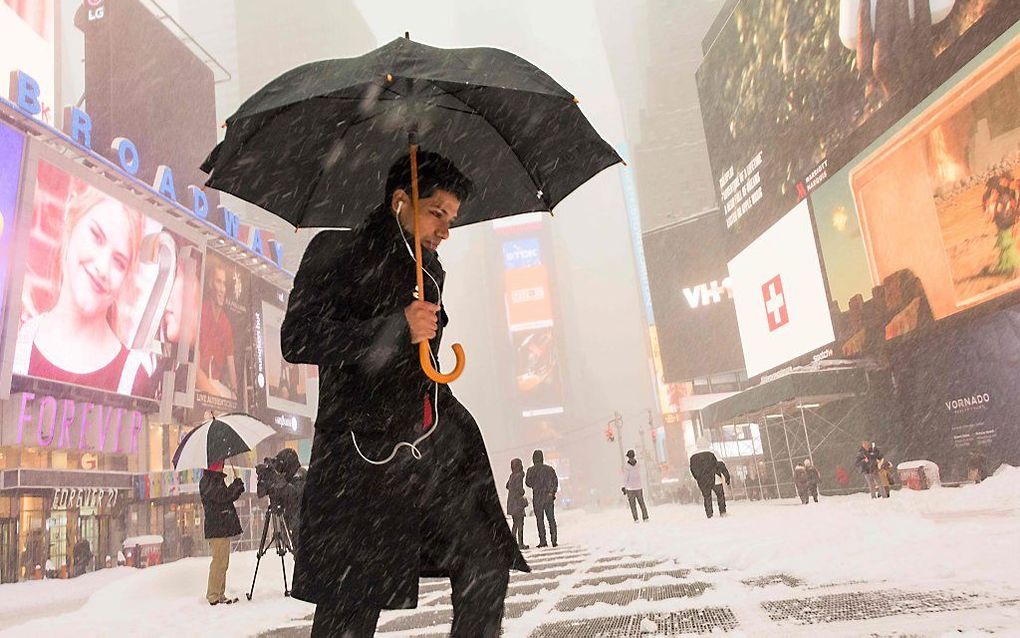 Een man trotseert het winterweer op Times Square in New York. beeld AFP