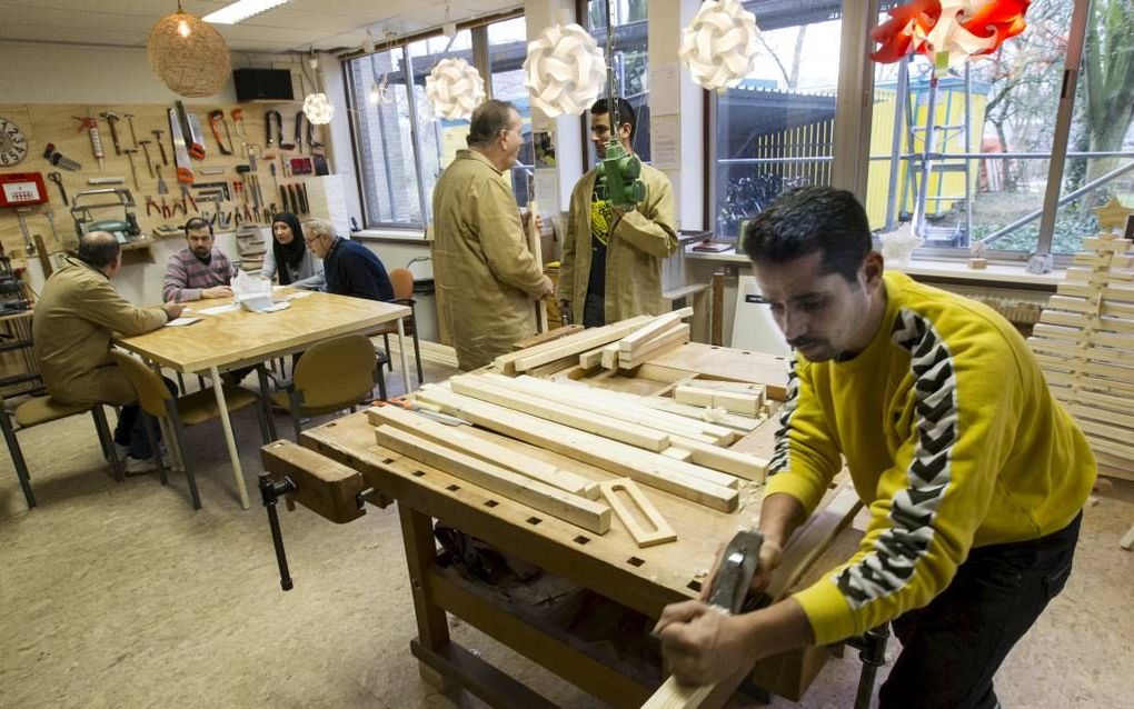 Arnhem voor Vluchtelingen organiseerde zaterdag een klusdag met asielzoekers. Mwaffag Rezklla (r) schaafde hout, Nedal Bouzan (29) (m) krijgt uitleg van begeleider Theo Vermeulen. Het klussen „geeft hen het gevoel dat ze ook waardevol zijn voor de mensen 