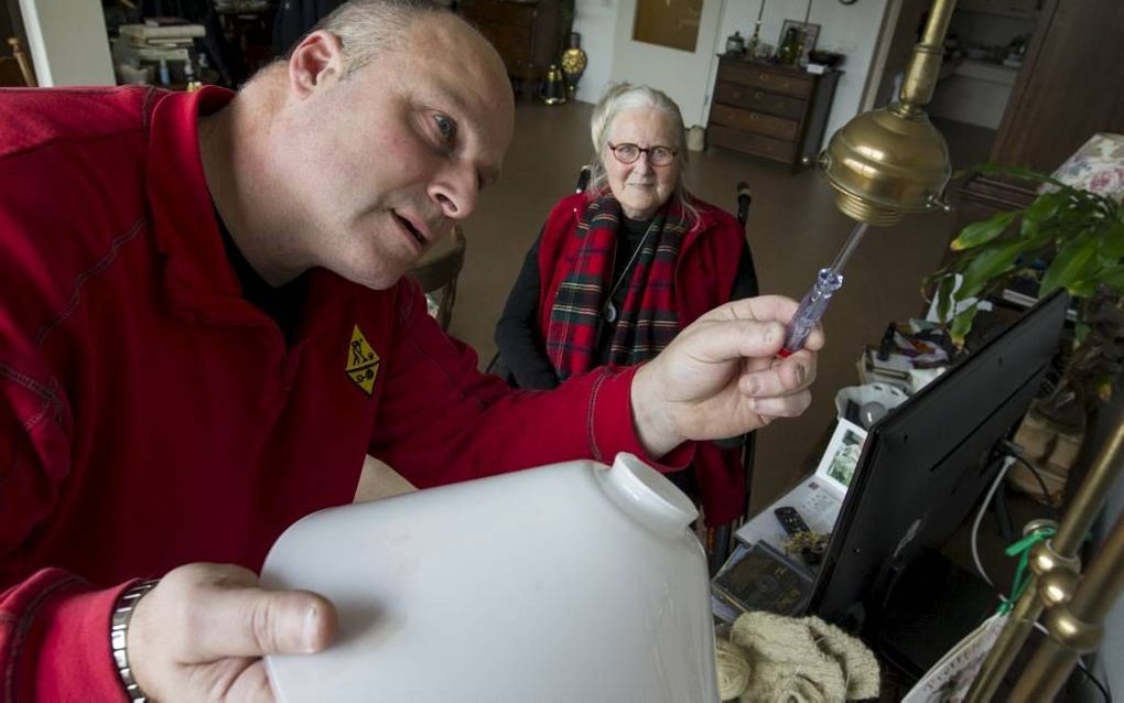 Alex van Beusekom van de klussendienst in Gorinchem doet een klusje bij mevrouw Van Rossem. Zij is een van de circa 600 mensen die gebruikmaken van deze dienst. beeld RD, Anton Dommerholt