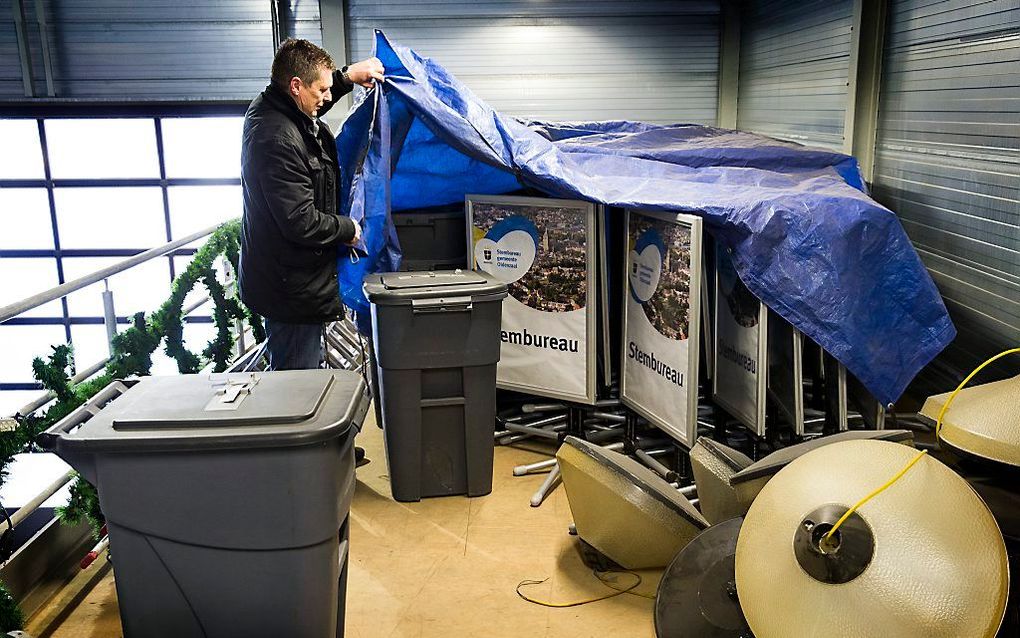 Een medewerker van de gemeente Oldenzaal inspecteert op de gemeentewerf de opgeslagen stembussen, stemhokjes en toebehoren voor de inrichting van stembureaus. Beeld ANP