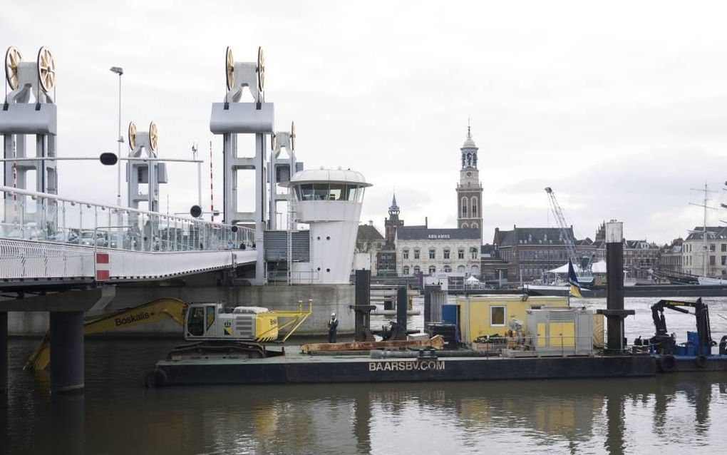 De graafinstallatie die bij de Stadsbrug in Kampen voorzichtig moet baggeren na de archeologische vondst van een middeleeuwse stadsbrug. beeld Michiel Satink