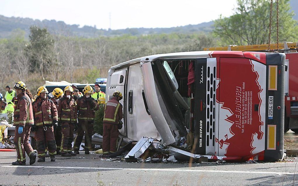 Hulpdiensten bij de gekantelde bus. Beeld EPA