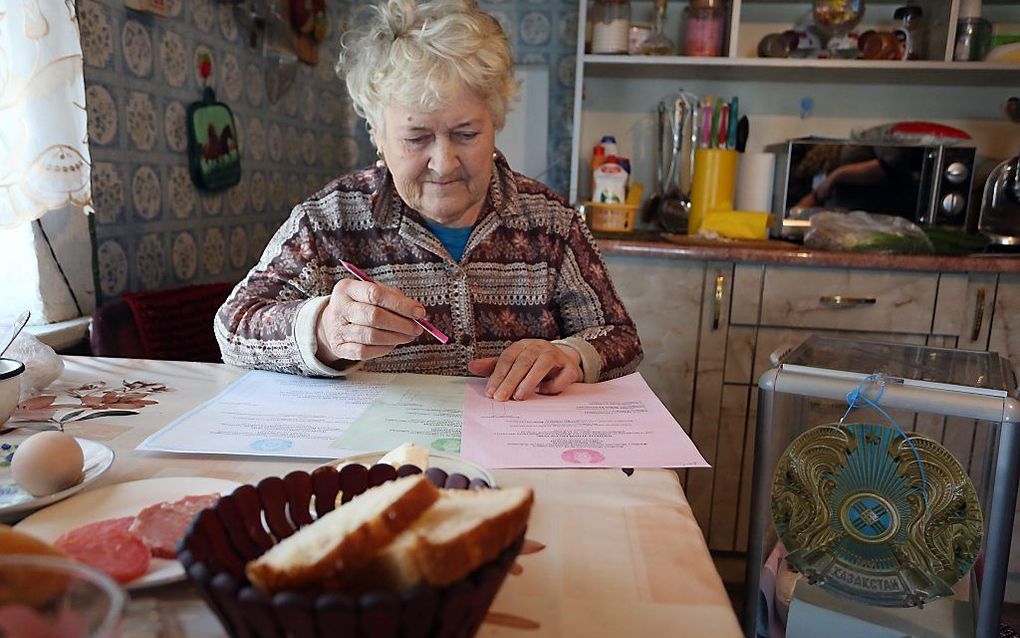 Een vrouw brengt in Kazachtstan haar stem uit voor de parlementsverkiezingen. Beeld EPA