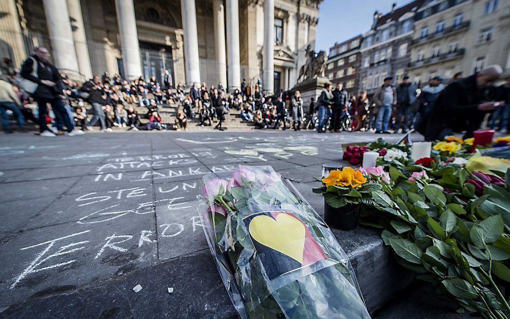 Op het Brusselse Beursplein worden met krijt leuzen en boodschappen van steun en liefde geschreven, bloemen neergelegd en kaarsen aangestoken. Hiermee tonen mensen hun solidariteit met de slachtoffers van de aanslagen in Brussel. Beeld ANP, JONAS ROOSENS