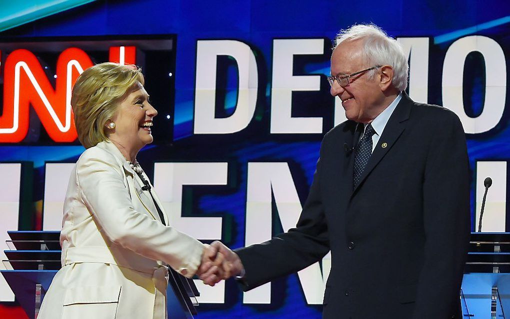 Clinton en Sandes schudden elkaar de hand voor de start van het CNN-debat. beeld AFP