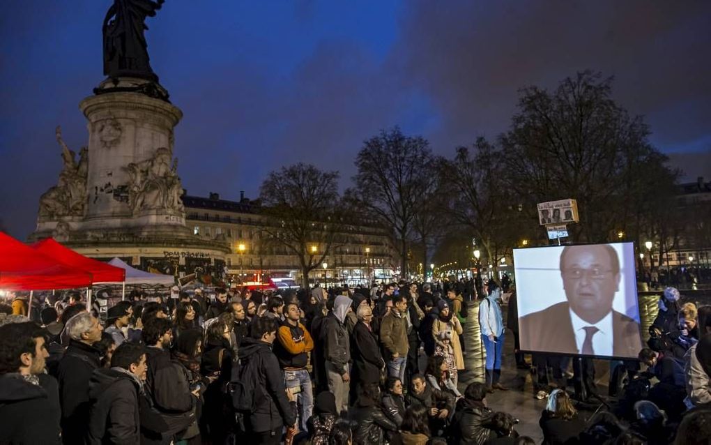 Demonstranten op het Place de la République in Parijs volgden donderdagavond een televisie-interview met president François Hollande over de aanhoudende protesten op het plein. beeld EPA, Ian Langsdon