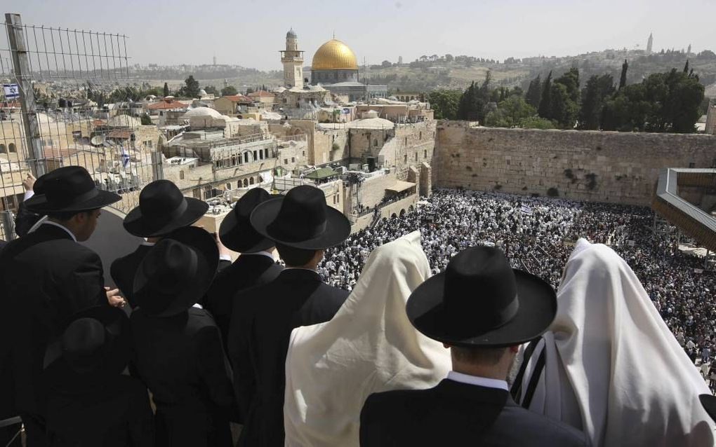 Joodse mannen woonden maandag bij de Westelijke Muur in Jeruzalem de ceremonie van de priesterzegen bij. Tijdens de achtdaagse viering van Pesach maken duizenden joden een pelgrimage naar Jeruzalem. beeld AFP, Menahem Kahana