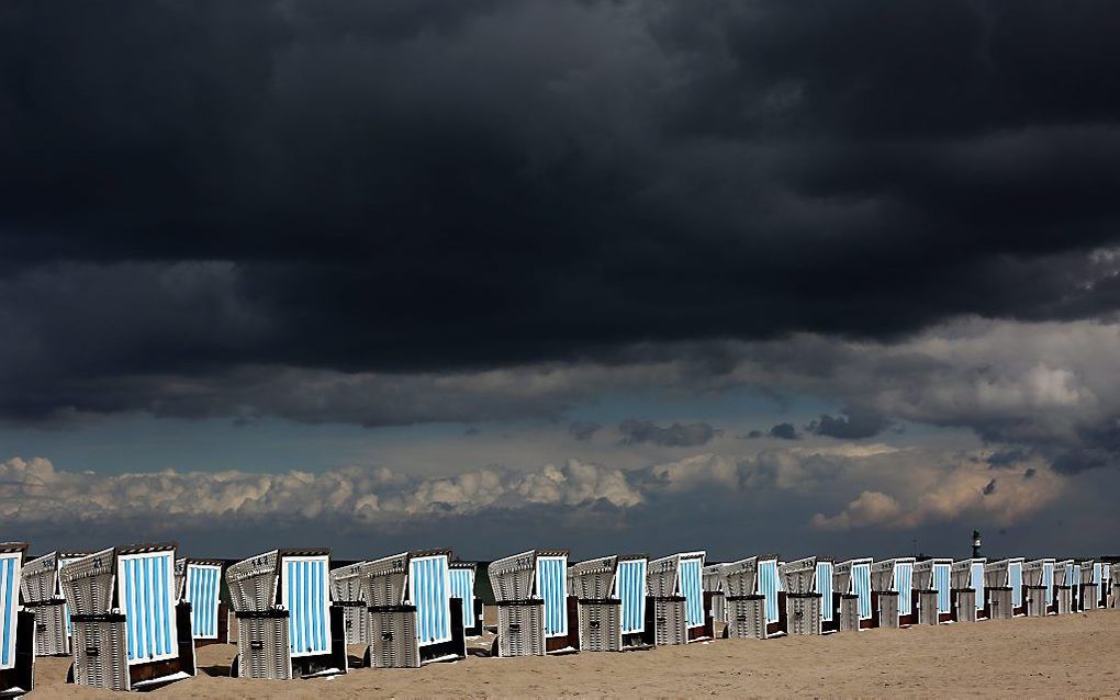 Donkere wolken pakken zich samen boven het strand bij Rostock-Warnemuende, Duitsland. beeld EPA