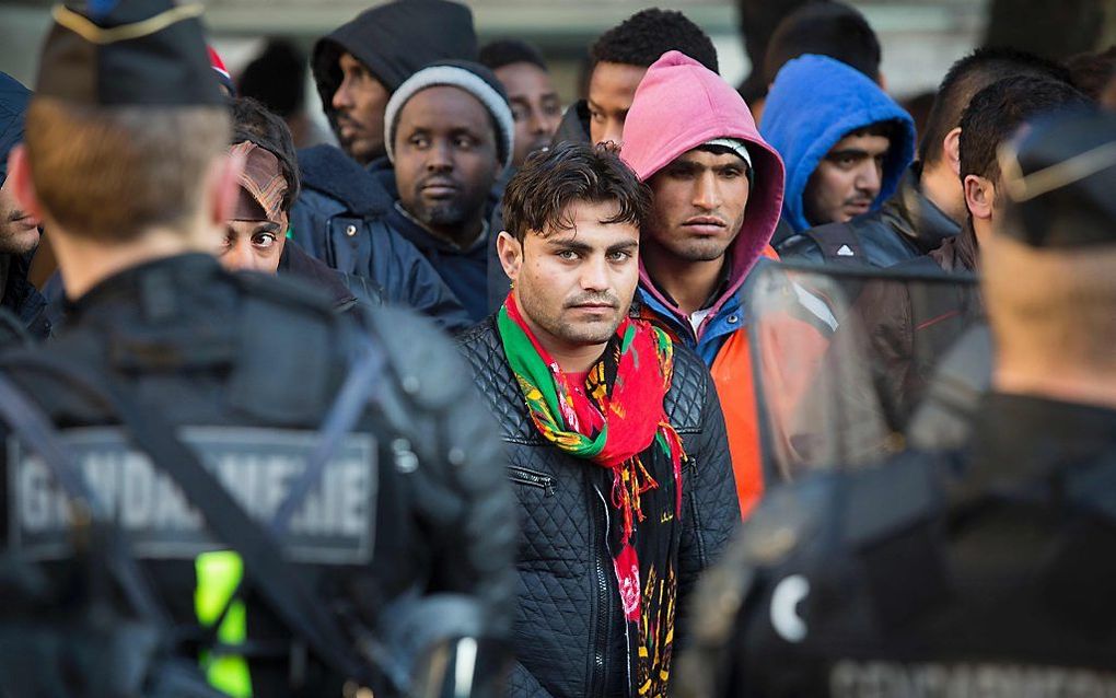 Migranten worden geëvacueerd door Franse politieagenten van een kamp onder metrostation Stalingrad in Parijs. beeld AFP