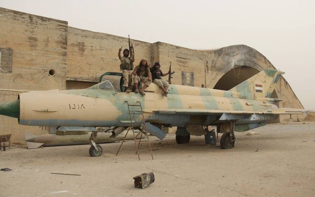 ABU DUHUR. Strijders van de aan al-Qaida-gelieerde Syrische al-Nusrabeweging poseren op een veroverd gevechtsvliegtuig van het Syrische leger, september 2015. beeld AFP, Omar Haj Kadour