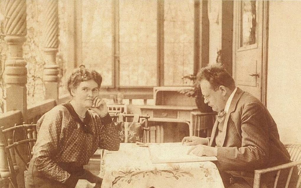 Max Reger corrigeert een manuscript, links zijn vrouw Elsa. Beeld Bach Museum Leipzig