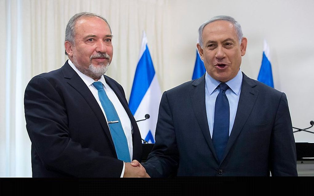 Minister president Natanyahu (rechts) schudt de hand van Lieberman. beeld EPA