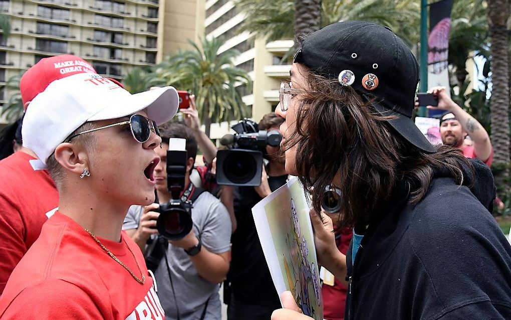 Een aanhanger en een tegenstander van Donald Trump in Anaheim. beeld EPA