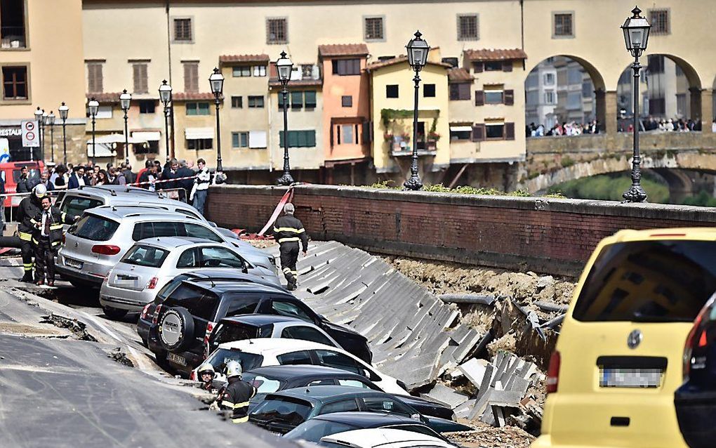 Ongeveer twintig auto’s zijn woensdag weggezakt toen de Lungarno Torrigiani, een kade langs de oever van de Arno in Florence, plotseling instortte. beeld EPA