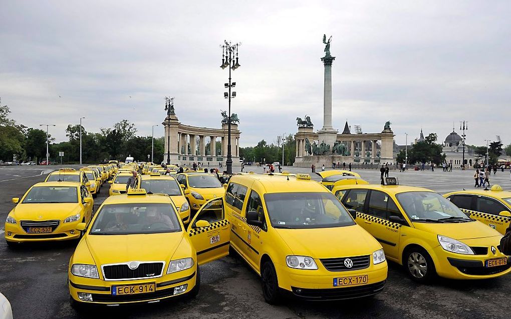 De taxidienst Uber is niet onomstreden onder reguliere taxichaufferus. Hier een demonstratie in mei in Budapest. beeld EPA