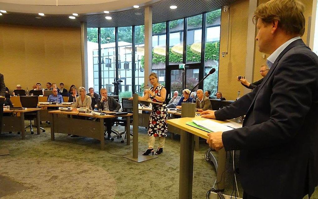 De raad van Smallingerland discussieert over de boycot van refobedrijf De Boer in Drachten. De vrouw achter het spreekgestoelde, met gebloemde jurk, is wethouder Ketelaar (PvdA). Rechts CDA-fractievoorzitter Jan Groen. beeld RD