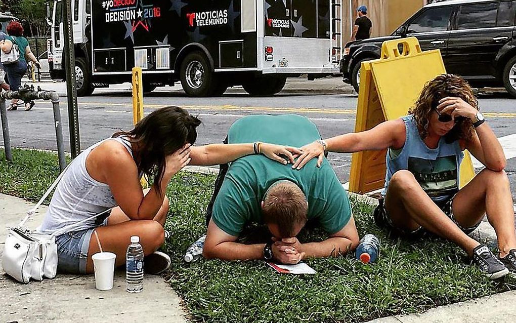 Mensen treuren na de schietpartij in de homoclub in Orlando. Beeld AFP