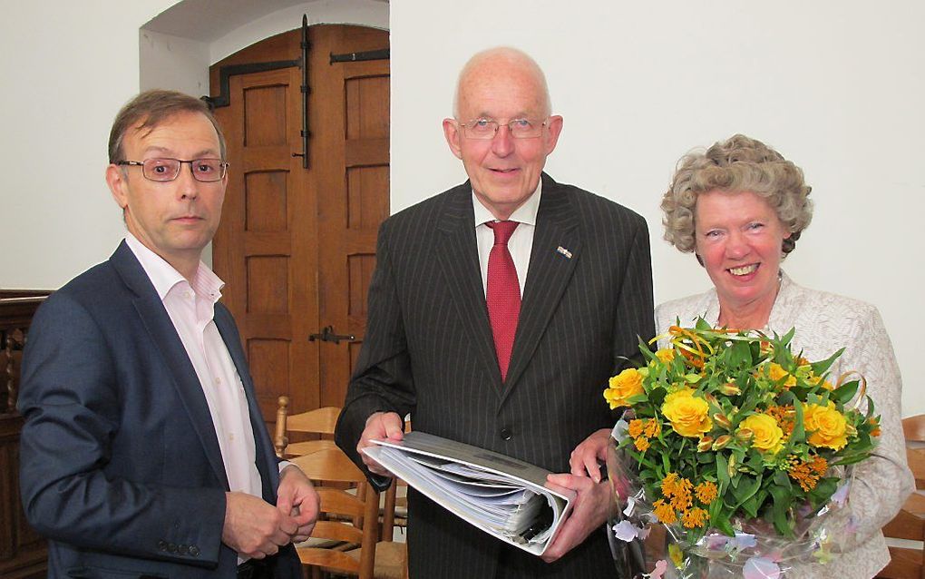 Hoofdorganist Vincent Hildebrandt (l.) overhandigt Henk Lemckert (midden) het “Liber amicorum”. Rechts Marian Lemckert. Beeld Pieter Baak