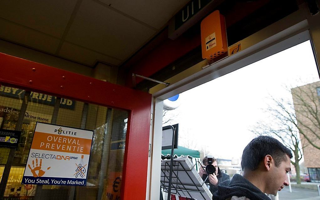 Een nep-overvaller krijgt DNA-spray over zich heen wanneer hij een winkel in Rotterdam verlaat.  beeld ANP, Robert Vos