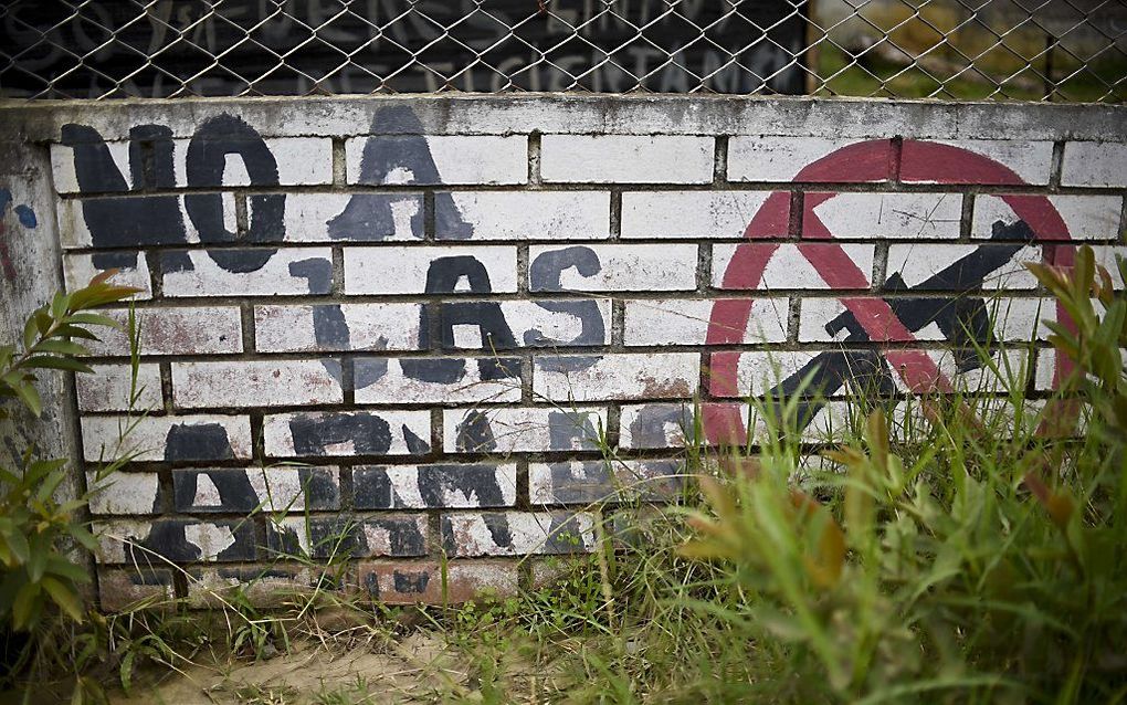 Een muurschildering in Colombia roept op om de wapens neer te leggen. beeld AFP