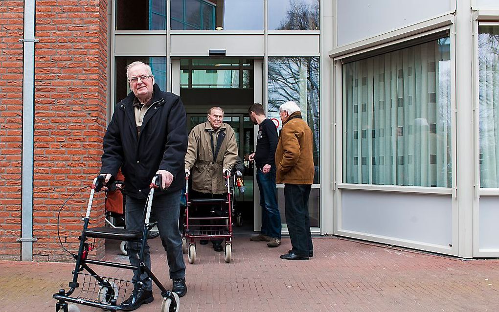 Twee ouderen verlaten verzorgingshuis Meulenvelden na de dagbesteding. In dit centrum worden activiteiten georganiseerd voor bewoners en senioren die elders wonen. beeld ANP