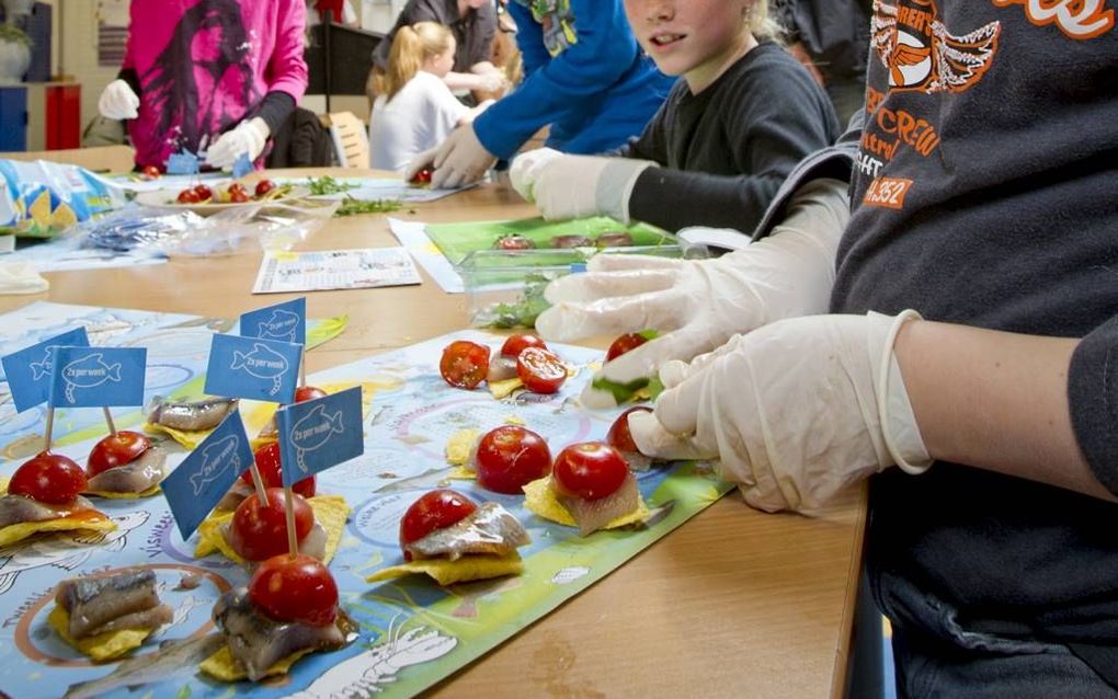 Kinderen van basisschool De Gong-Matendonk in Apeldoorn maakten maandag zelf haringhapjes, die ze daarna gingen proeven en beoordelen. Foto Nederlands Visbureau