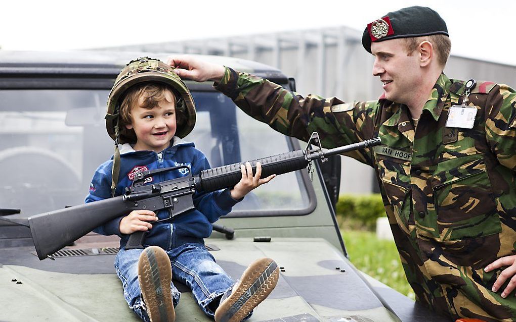 Een jonge bezoeker met helm en nepwapen tijdens de jaarlijkse Landmachtdagen in Oirschot. Foto ANP