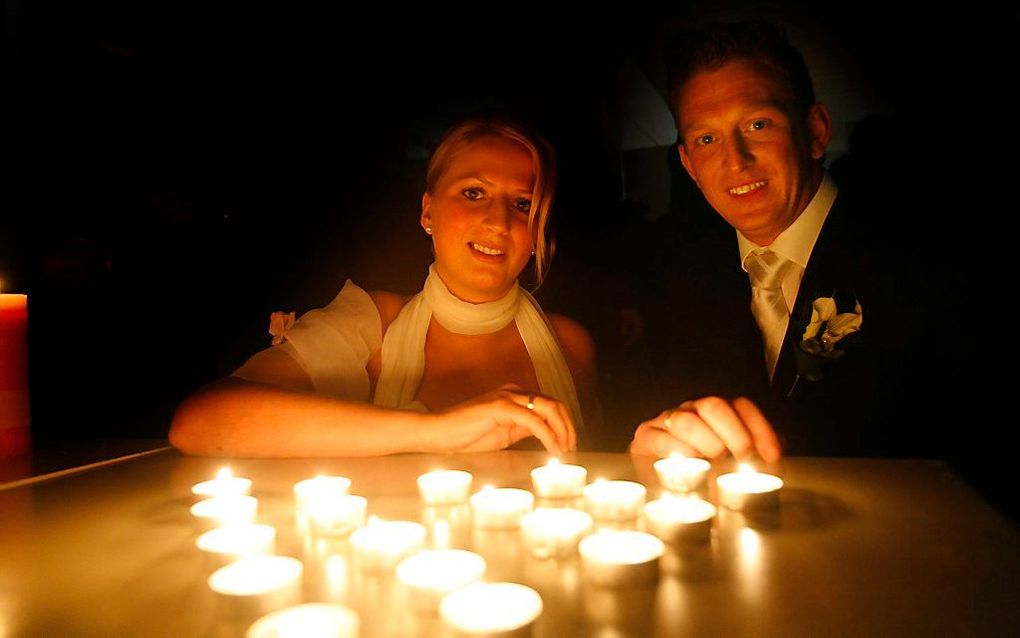 Joost Dooijenburg en Ilse ter Meer trouwen door de stroomstoring in het donker. Foto ANP