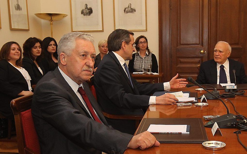 De Griekse president Papoulias (rechts), tijdens onderhandelingen maandagavond met Samaras (2e van links) en Kouvelis. Foto EPA