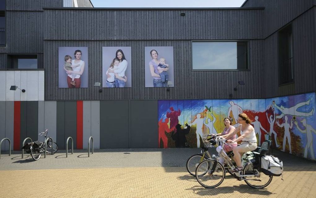 De buitenmuren van centrum De Kamers in Vathorst doen dienst als expositieruimte voor een serie portretten van moeders met kinderen. Foto Wessel van Binsbergen