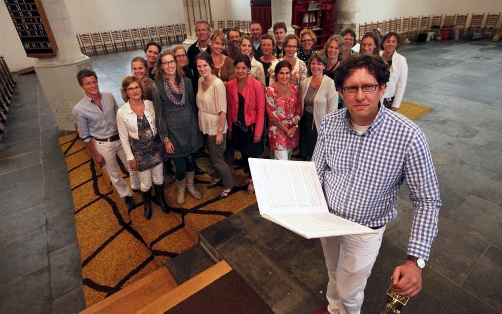 Dirigent Arjen J. A. Uitbeijerse, met op de achtergrond christelijk vocaal ensemble Marcantus. „Je werkt samen aan een gemeenschappelijk doel.” Foto Martin Droog