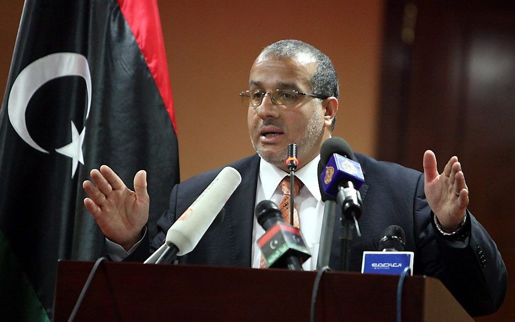 Minister Omar Al-khadrawi tijdens een persconferentie over de situatie rond het vliegveld van Tripoli.   Foto EPA