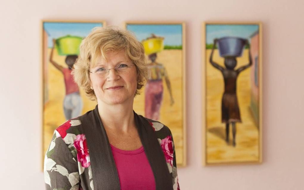 ZEIST – Dr. Regien Smit voor een drieluik met daarop drie Angolese vrouwen. Smit promoveerde vorige week op een studie waarin een Angolese en een Braziliaanse pinksterkerk in Rotterdam centraal staan. Foto André Dorst