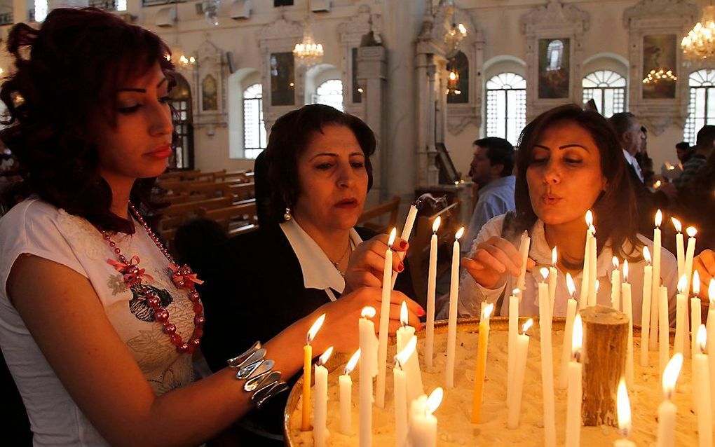 Syrische orthodoxe christenen steken kaarsen aan in de Maryamiyehkerk in Damascus, eerder dit jaar. Foto EPA