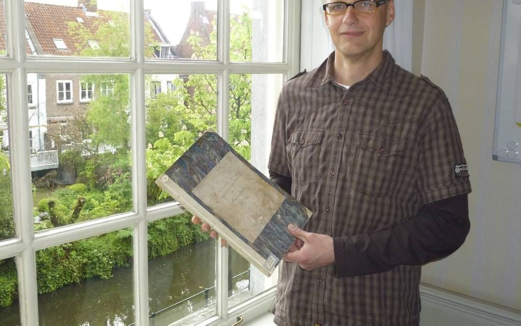 De Amersfoortse gemeentearchivaris Dirk Steenbeek met het kerkrekeningenboek in zijn handen. beeld RD