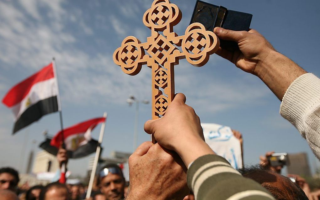 Tijdens een demonstratie in Egypte in februari vorig jaar hield iemand een koptisch kruis omhoog. Foto EPA