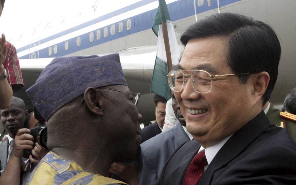 De Chinese president Hu Jintao (r.) wordt verwelkomd door de toenmalige Nigeriaanse president Olusegun Obasanjo, bij aankomst op de luchthaven van de Nigeriaanse hoofdstad Abuja, april 2006. Foto AFP