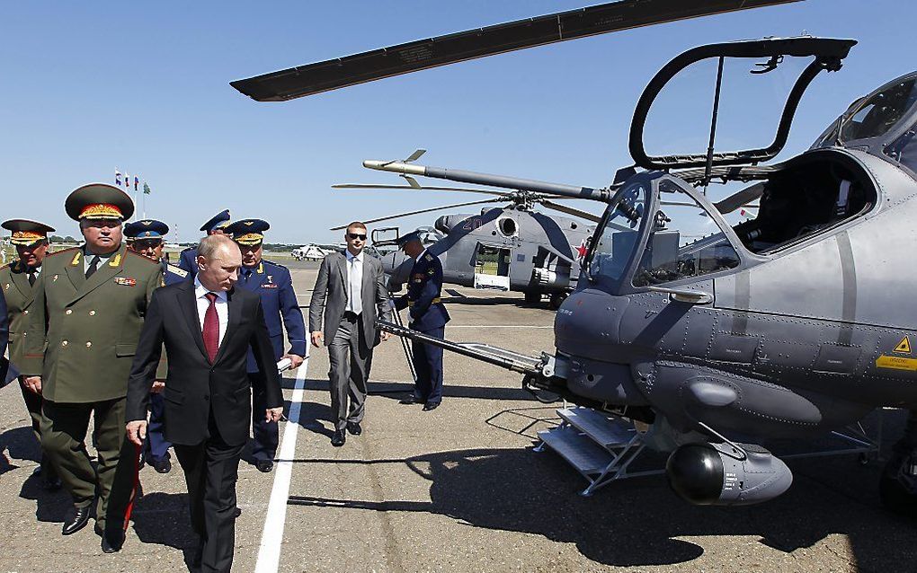 De Russische president Poetin bekijkt een gevechtshelikopter. Rusland heeft aangegeven geen wapens te zullen leveren aan Syrië. Foto EPA