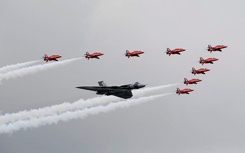 De Red Arrows, het demoteam van de Britse luchtmacht begeleidt een Vulcan-bommenwerper bij de opening van de Farnborough International Airshow. Foto EPA