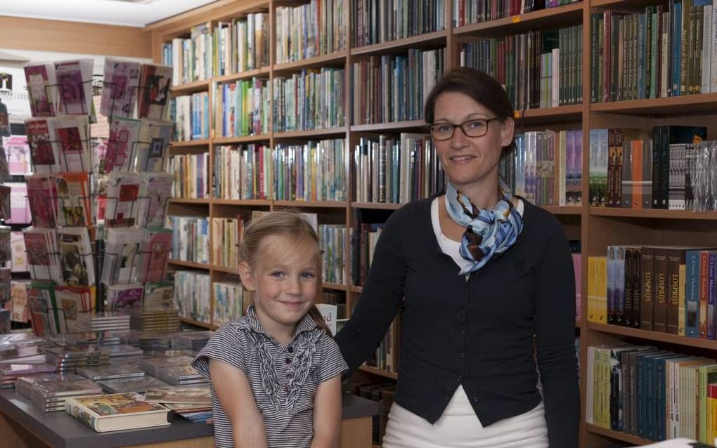 Gerda Spelt met dochtertje Rhodé in de boekhandel, gevestigd in een garagebox in Uddel. Foto André Dorst