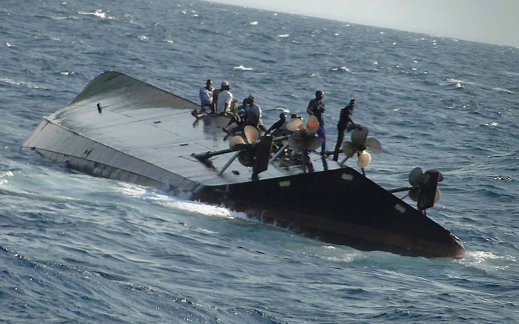 Overlevenden wachten op redding op de omgeslagen veerboot. Foto EPA