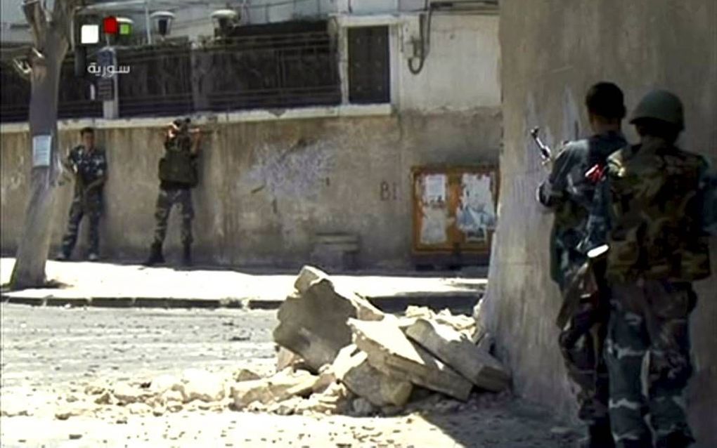 Syrische militairen namen woensdag posities in na de verwoestende bomaanslag op een gebouw van de veiligheidsdienst in de hoofdstad Damascus. Drie topfiguren van het Syrische regime kwamen bij de aanval om het leven. Foto EPA