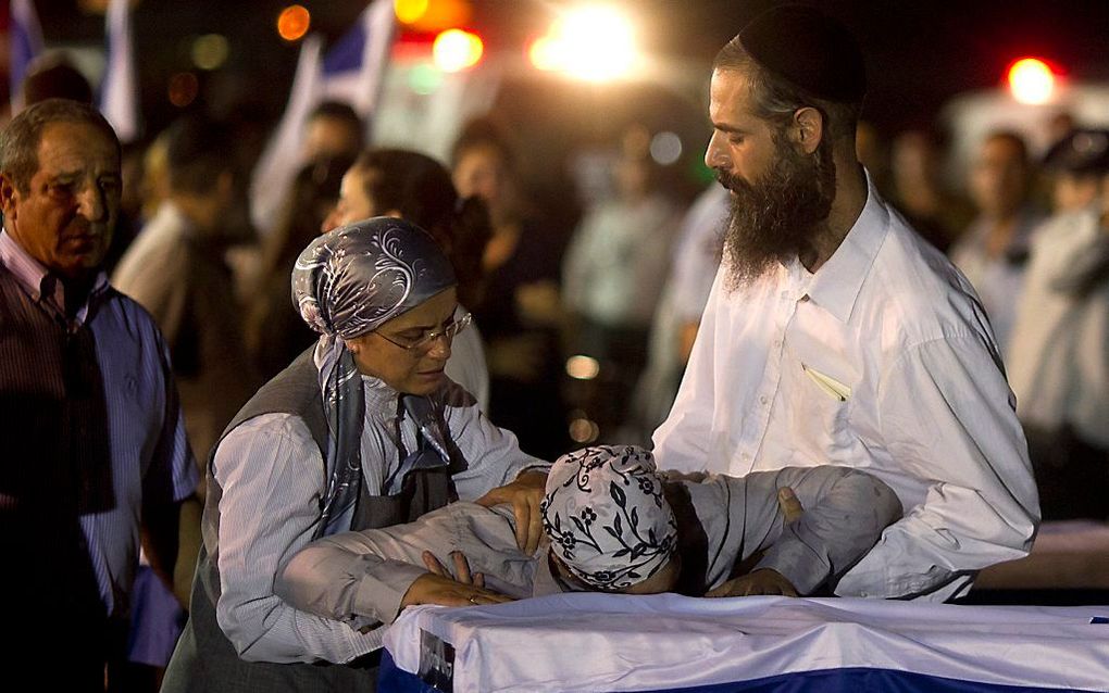 Familieleden rouwen bij de kisten op het vliegveld van Ben Gurion, Tel Aviv. Foto EPA