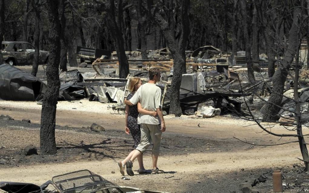 Een paar loopt over camping Les Pedres in het Noord-Spaanse Capmany, die zondag in korte tijd volledig werd verwoest door bosbrand. Foto ANP