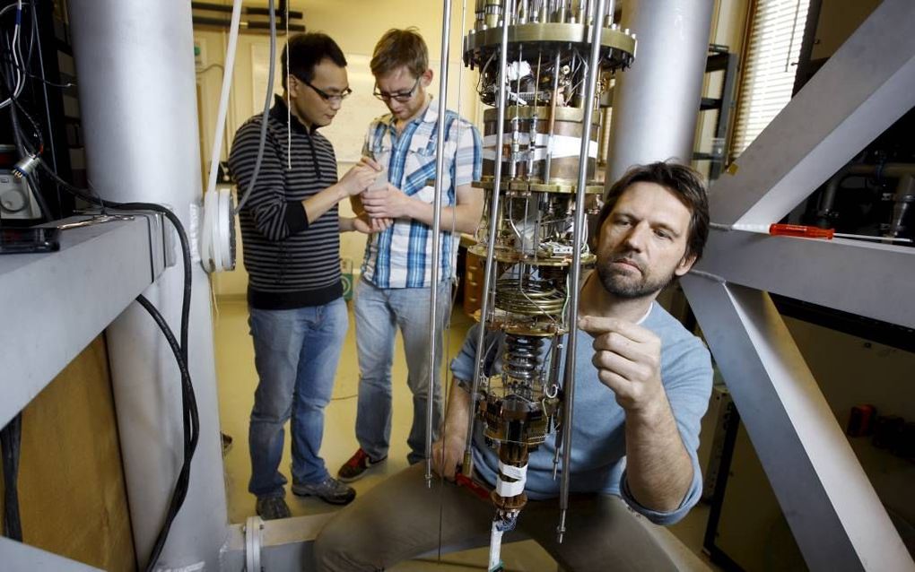 De Delftse onderzoeksgroep aan het werk in het laboratorium waar zij het langgezochte majoranadeeltje hebben gevonden. V.l.n.r. Kun Zuo, Vincent Mourik en Leo Kouwenhoven (voorgrond). Foto Sam Rentmeester