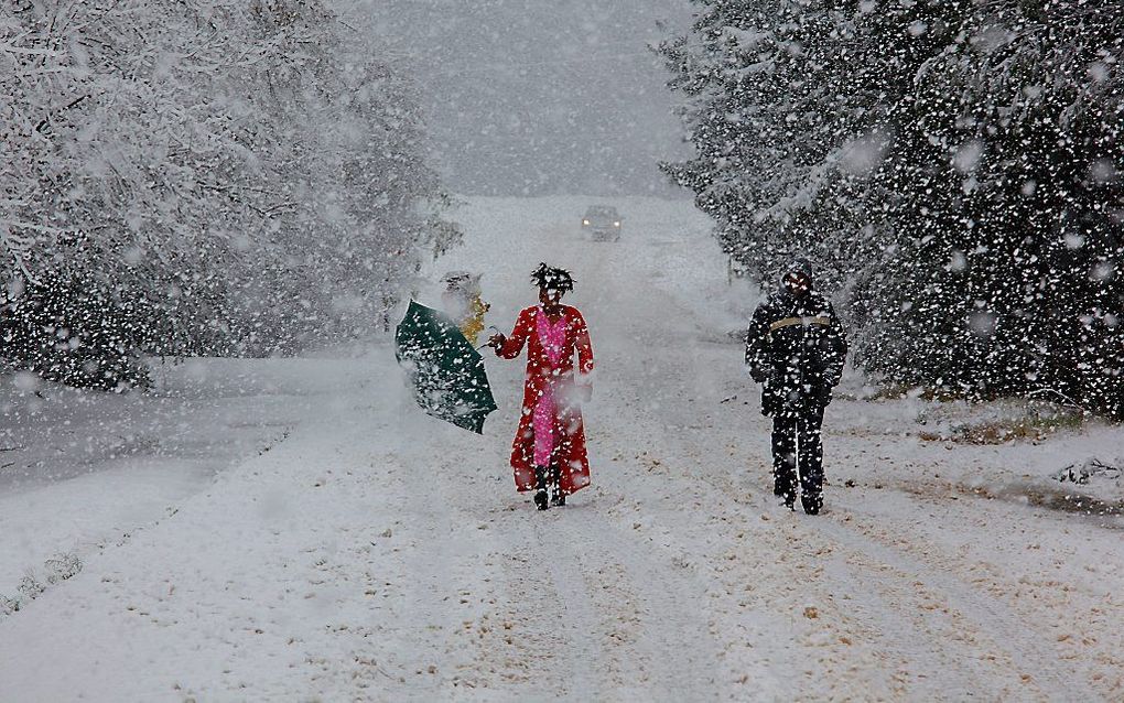 Inwoners van Nottingham Road, Zuid-Afrika, lopen dinsdag door de sneeuw nadat een massief koudefront over het land trok. Het land kent de hevigste sneeuwval sinds 15 jaar. Foto EPA