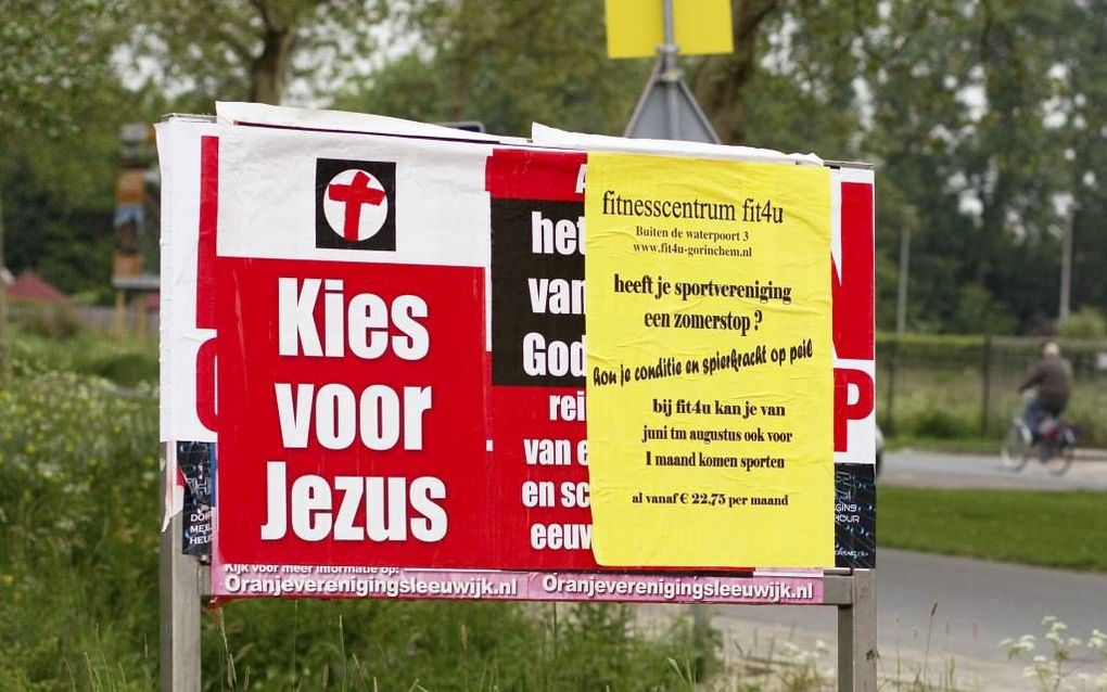 ”Kies voor Jezus”, zegt een aanplakbord in Gorinchem-Noord, bij de oprit naar de Gomarus Scholengemeenschap. De poster is over een aanplakbiljet van de SP geplakt. Foto Dirk Hol