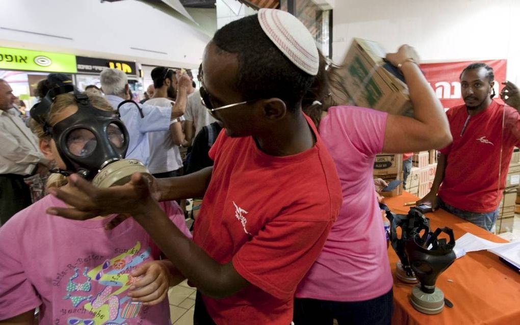 De 11-jarige Eleanor Sidikman (l.) paste gisteren een nieuw gasmasker. Nu de dreiging van een Israëlische aanval op Iran toeneemt, verruilen Israëliërs massaal hun oude gasmaskers voor nieuwe, die gratis worden uitgedeeld. Foto EPA