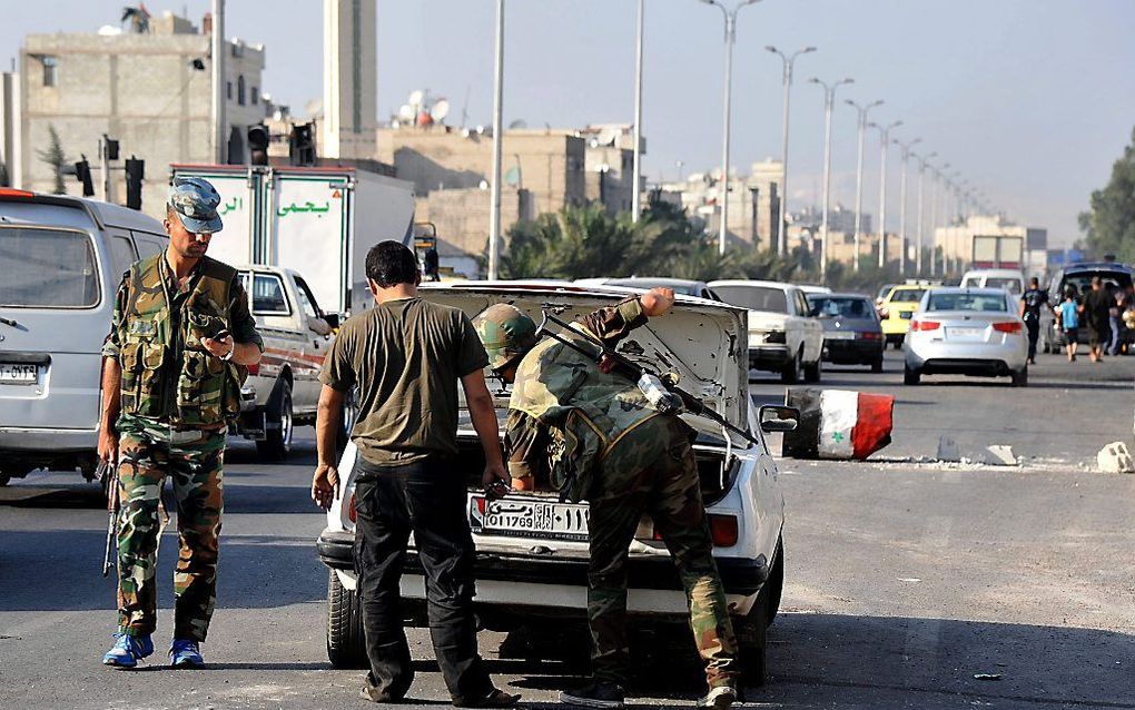 Syrische militairen controleren een auto in Damascus. Foto EPA