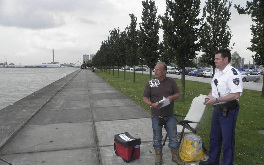 Wijkagent Diede de Leeuw controleert een visser aan de Noordzijde van de Waalhaven in Rotterdam. Foto RD